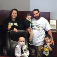 <p>Gio Toribio, police chief for the day in Ossining, at his desk with mom, Lauren; dad, Juan; and his little brothers.</p>