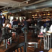 <p>There are plenty of tables at Growler &amp; Gill where folks can hang out with a few craft beers and a thin-crust pizza.</p>