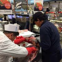 <p>Workers at a H Mart slice up some fresh fish. The New Jersey-based supermarket chain, which specializes in Asian foods, is opening a new location in Yonkers.</p>