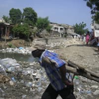 <p>A man works to clear debris after the devastating 2010 earthquake in Haiti. A local organization is holding two fundraising events to aid the struggling island.</p>