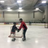 <p>Volunteer Justin Italiano of Rutherford helps a member of the NJ Avalanche learn to balance and skate.</p>