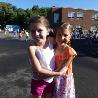 <p>Holmes School second-grader Lila McKeone and third-grader Sylvia Mickels are excited to see each other during morning recess on the Holmes School playground.</p>