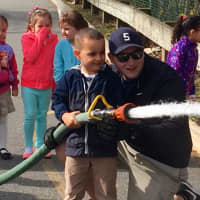 <p>A firefighter in the making? Assistant Engineer Nick Kopacz showed school children how to properly extinguish a fire.</p>