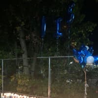 <p>Mourners placed candles and balloons at the site where a Norwalk teen was killed.</p>