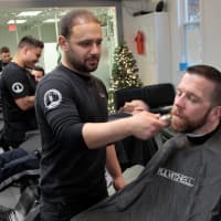 <p>Evan Vidal, owner of the Shave Bar in Hillsdale, shaves an officer.</p>