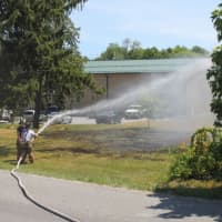 <p>Mahopac firefighters douse the flames of the brush fire.</p>