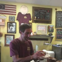 <p>Michael Narciso, a Suffern resident and co-founder of Mia&#x27;s Kitchen, serves up one of Mia&#x27;s many gluten free baked good options.</p>