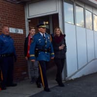 <p>Fair Lawn Capt. Robert Kneer walks out of the Fair Lawn Police Department one last time on Friday, accompanied by children Katrina and RJ. Looking on is Officer Edward Egan.</p>