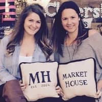 <p>Chelsea Quinn and Sarah Christensen sit outside Market House in Westwood.</p>