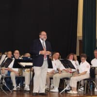 <p>Sal LaRusso, director of the Westport Community Band, speaks to the audience in Westport Town Hall before the band performs for the Veterans Day service.</p>