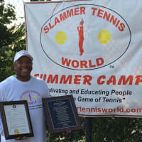<p>Marvin Tyler of Slammer Tennis World of Norwalk stands with a proclamation and plaque that were given to him by his hometown community in Emporia, Va.</p>
