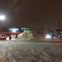 <p>Travelers braving the roads pull into the Dunkin Donuts on Passaic Street to pose with the mountain of snow.</p>