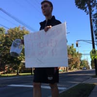 <p>Glen Rock High School junior Colin Morrow directs motorists to the event.</p>
