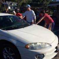 <p>Glen Rock hockey players wash down one of the cars at a fundraiser for the program Saturday, Oct. 10 on South Maple Avenue.</p>