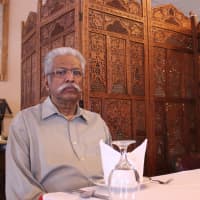<p>John George, owner of Priya Indian Cuisine, sits at a table inside his restaurant in Suffern.</p>