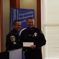 <p>Easton Police Chief Tim Shaw smiles as he accepts a donation from the Gleszer bequest from Danbury Sgt. James Antonelli at a ceremony in Danbury Thursday.</p>