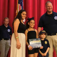<p>Krista, Alanna and Alex Hammer stand with Lt. Rich Skinner.</p>