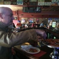 <p>Ed Ogle of Lyndhurst goes for another slice of his pepperoni and olives pizza at New Park Tavern in East Rutherford Oct. 17.</p>