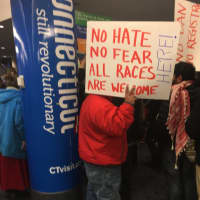 <p>The protest at Bradley International Airport greets arriving passengers — along with a pole emblazoned with the state&#x27;s tourism motto: Connecticut Still Revolutionary.</p>