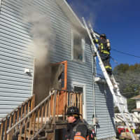 <p>Danbury firefighters tackle a blaze at 23 McDermott St. on Friday afternoon.</p>