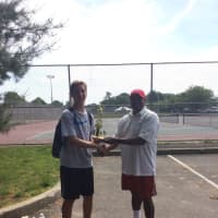 <p>Marvin Tyler presents a trophy to one of the young boys in the tournament.</p>