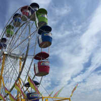 <p>A ferris wheel spins below a perfectly blue sky at the Oyster Festival Saturday. </p>