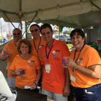 <p>Volunteers at the Oyster Festival Saturday pose for a picture at the ticket booth for the craft beer tent. </p>