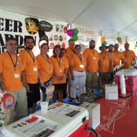 <p>Several volunteers pose for a photo inside the craft beer tent at the Oyster Festival Saturday.</p>