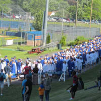 <p>The procession of graduates stretches from the football field back to the gym at the Danbury High graduation on Thursday.</p>