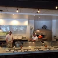 <p>Workers prepare pizza at Brick + Wood Tuesday.</p>