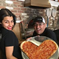 <p>Sara and Marco show off their latest creation at Francesca Pizzeria, located in Glen Rock. The Elmwood Park shop created pizzas just like it.</p>