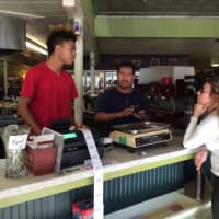 <p>Harborview Market employees Thomas Cooper and Antonio Oaxaca talk about Tuesday election results with customer Candice Cole.</p>
