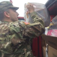 <p>A military member from the Teaneck Armory loads toys into a truck headed to the hospital.</p>