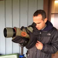 <p>Nick Bonomo of Walllingford scans the sky for birds at Stratford Point.</p>