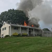 <p>A home in Norwalk is engulfed in flames reportedly caused by a lightning strike, according to the Norwalk Fire Department.</p>