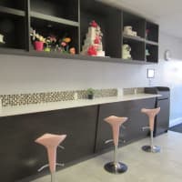 <p>Pink petal stools line the wall across from the shop&#x27;s booths.</p>