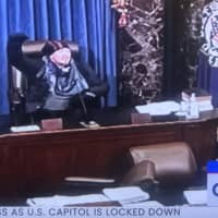 <p>One of the rioters who stormed the Capitol building took to the dais in the chamber.</p>