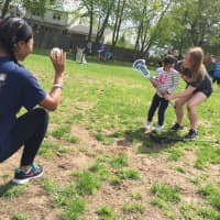 <p>Saddle Brook High School varsity lacrosse players Kayla Chowdhury and Karissa Quimby help a young &quot;Angel&quot; get a feel for the stick Saturday at Avon Field.</p>