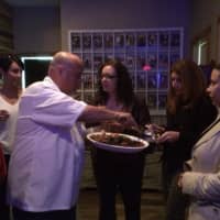 <p>Chris Delmonico serves crab cakes to his guests at Lazy Dog Tavern.</p>