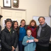 <p>Sophie Pennock Collins, 8, making a donation at the Black Rock Food Pantry with her moms, Tara Collins, second from left, and Laura Pennock, fourth from left. </p>