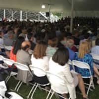 <p>The crowd settles in under the tent at the Weston High graduation.</p>