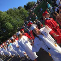 <p>The Processional marches onto the field for the Masuk High graduation on Tuesday.</p>