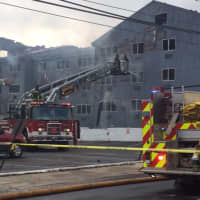 <p>Firefighters fight a smoldering blaze at 215 Charles Street in Bridgeport.</p>