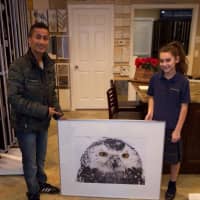 <p>Peekskill photographer Anwar Alomaisi presents 12-year-old Sophia Del Monte a framed photo of the snowy owl.</p>