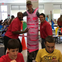 <p>Benjamin Franklin Middle School substitute teacher Dan Cermac hangs out in the school cafeteria after being taped to the wall by Ridgewood students.</p>