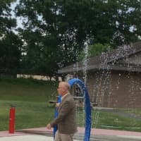 <p>Danbury Mayor Mark Boughton dodges the drops at the new spray park at Kenosia Park.</p>