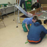 <p>Members of Mamaroneck High School&#x27;s robotics club at work near the &quot;playing field&quot; used by their new robot to climb a mountain of debris and pick up other debris.</p>