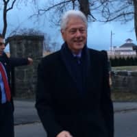 <p>Clinton strides across Grovers Avenue to greet fans waiting in the cold.</p>