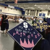 <p>Students have fun with their mortarboards at the Staples High graduation.</p>