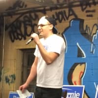 <p>Jacob Robison of Bridgeport warms up the crowd at a Bernie Sanders rally at a city skate shop.</p>